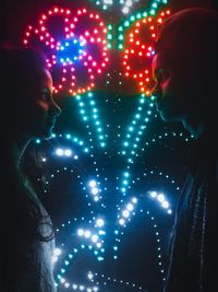 Woman in illuminated christmas lights at night