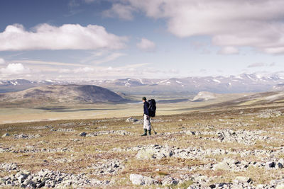 Man standing on landscape against sky