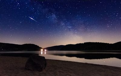 Scenic view of lake against sky at night