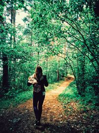 Full length of woman walking on footpath in forest