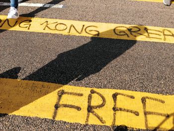 High angle view of yellow arrow sign on road in city