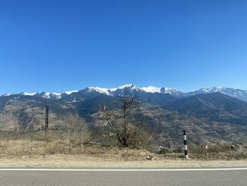 Scenic view of snowcapped mountains against clear blue sky