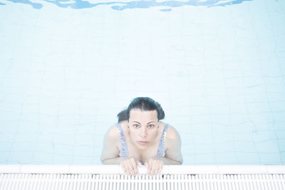 Portrait of young woman swimming in pool