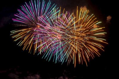 Low angle view of firework display at night