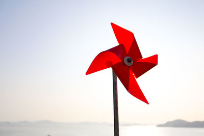 Close-up of red pinwheel toy against sky