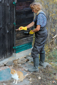 A woman varnishing old bark and a cat