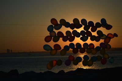 Close-up of pebbles on beach against sky during sunset