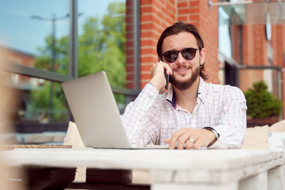 Portrait of smiling man sitting at outdoor cafe