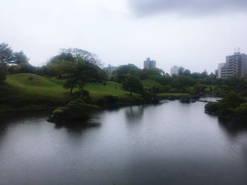 Scenic view of river by trees against sky