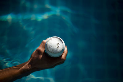 Selective focus white beer can in hand. man is soaking in the pool with an open beer can relax 