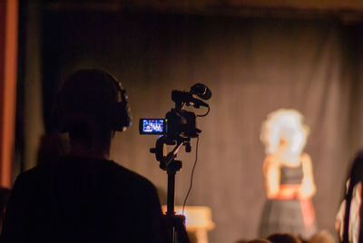 Rear view of camera operator at stage theater