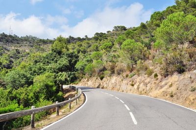 Road amidst trees against sky