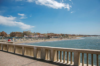 View of marble pier, with the beach and the city of ostia in italy.