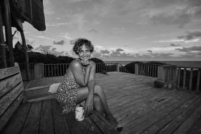 Portrait of women sitting on seat against sky