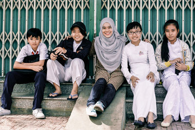 Portrait of friends sitting on group of people