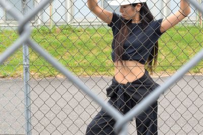 Female hip hop dancer seen through chainlink fence