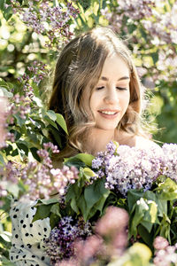 Portrait of a smiling young girl in blooming lilac trees. summer time,vacation.
