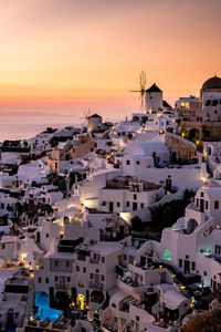 High angle view of townscape by sea against sky during sunset