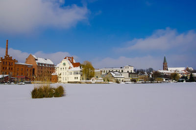 View of houses in town against cloudy sky