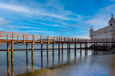 View of bridge over sea against cloudy sky