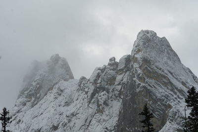 Low angle view of snowcapped mountains against sky