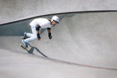 Man in helmet skateboarding on sunny day