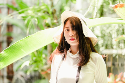 Portrait of beautiful woman standing against plants