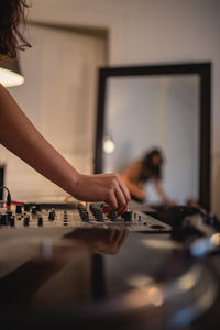 Cropped hand of woman playing sound mixer at home