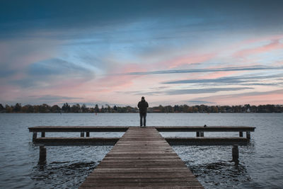 Man on jetty looking at sunset