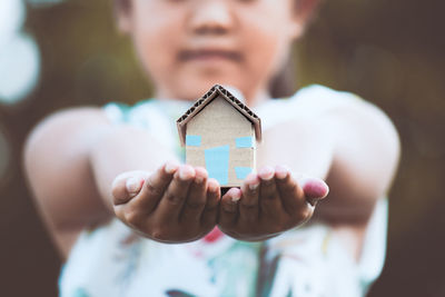 Defocused midsection of girl holding toy home