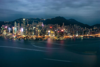 The illuminated skyscrapers along the waterfront at victoria harbour in hong kong