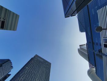 Low angle view of modern buildings against clear blue sky