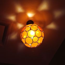 Low angle view of light bulb hanging from ceiling