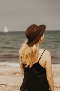 Rear view of woman looking at sea against sky