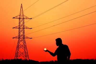 Silhouette of man standing at sunset