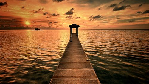 Scenic view of pier on sea against sky during sunset