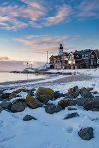 Scenic view of sea and buildings against sky during sunset