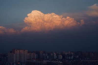 Buildings in city against sky at sunset