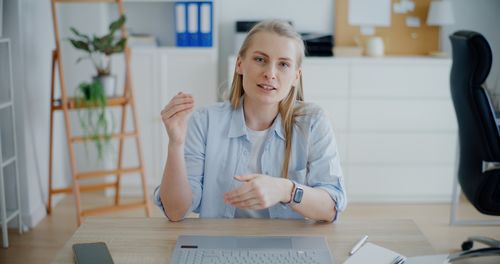 Portrait of young woman working at desk in office