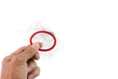 Close-up of hand holding eyeglasses against white background