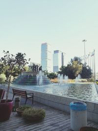 Swimming pool in city against clear sky