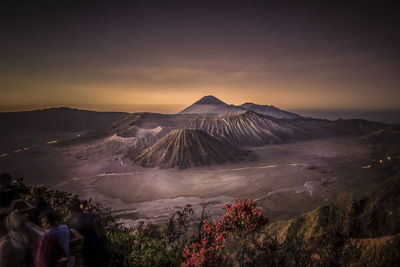 Panoramic view of people on mountain against sky during sunset