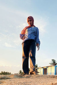 Full length of woman standing on land against sky