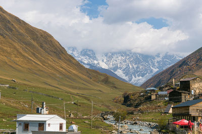 Houses by mountains against sky