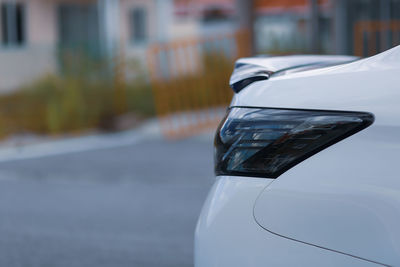 Close-up of white car on street