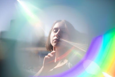 Woman amidst lens flare in city
