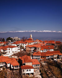 High angle view of townscape against blue sky and mountains 