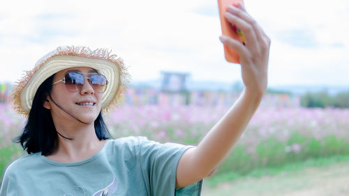 Close-up of smiling woman taking selfie on field