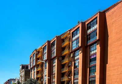 Low angle view of apartment building against blue sky