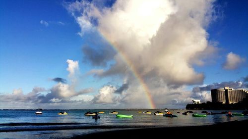 Boats in sea against cloudy sky